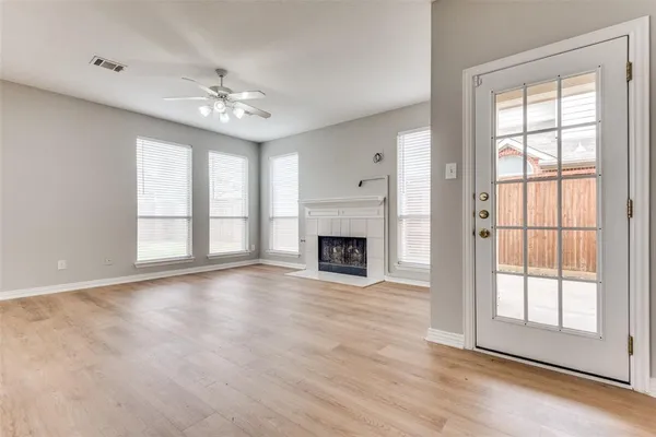 a view of an empty room with chandelier and fireplace
