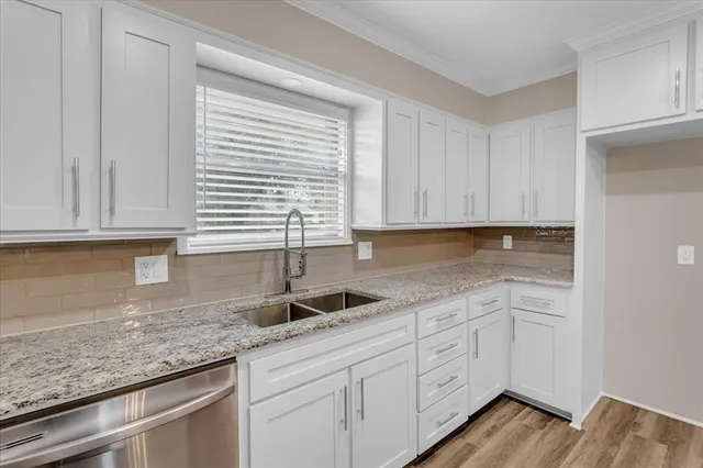 a kitchen with granite countertop white cabinets sink and dishwasher