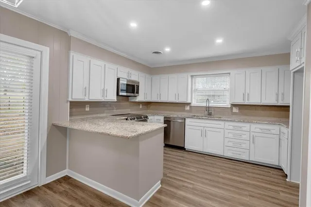 a kitchen with granite countertop white cabinets and white appliances