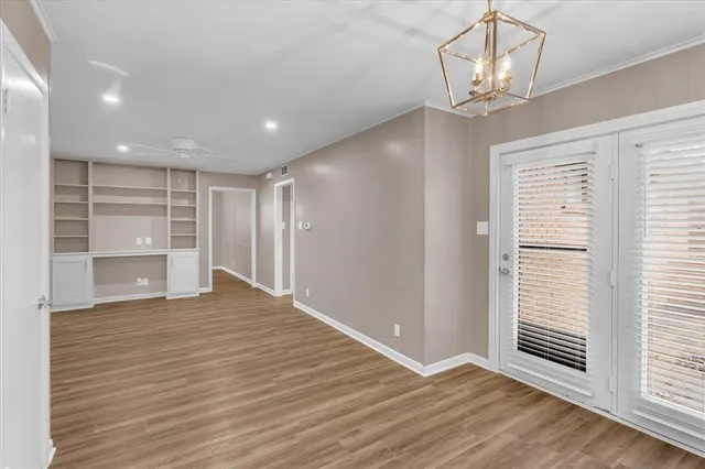 a view of empty room with wooden floor and window