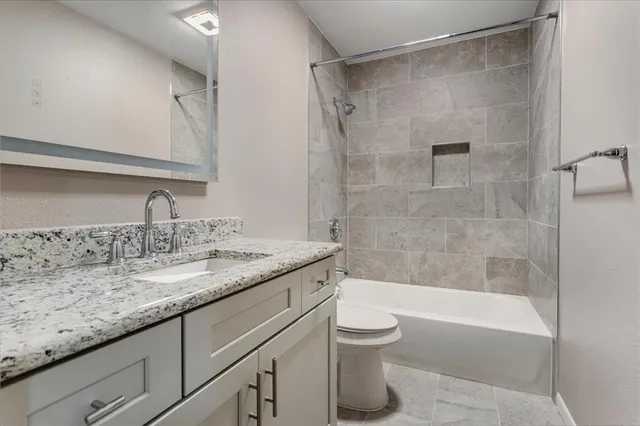 a bathroom with a granite countertop sink toilet and shower