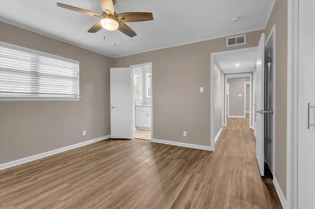 a view of a room with wooden floor and ceiling fan