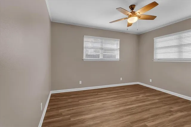 a view of an empty room with a window and a ceiling fan
