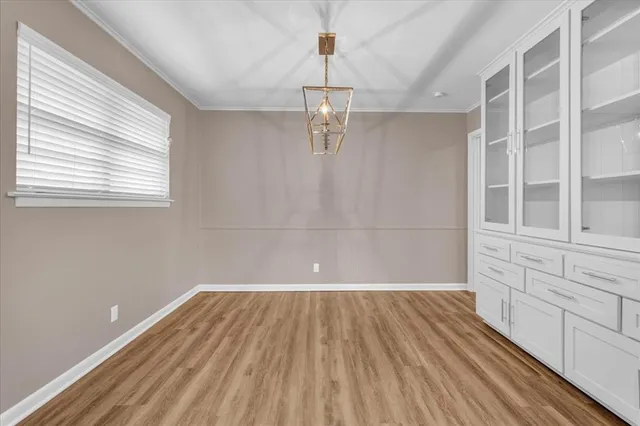 a view of empty room with wooden floor and windows