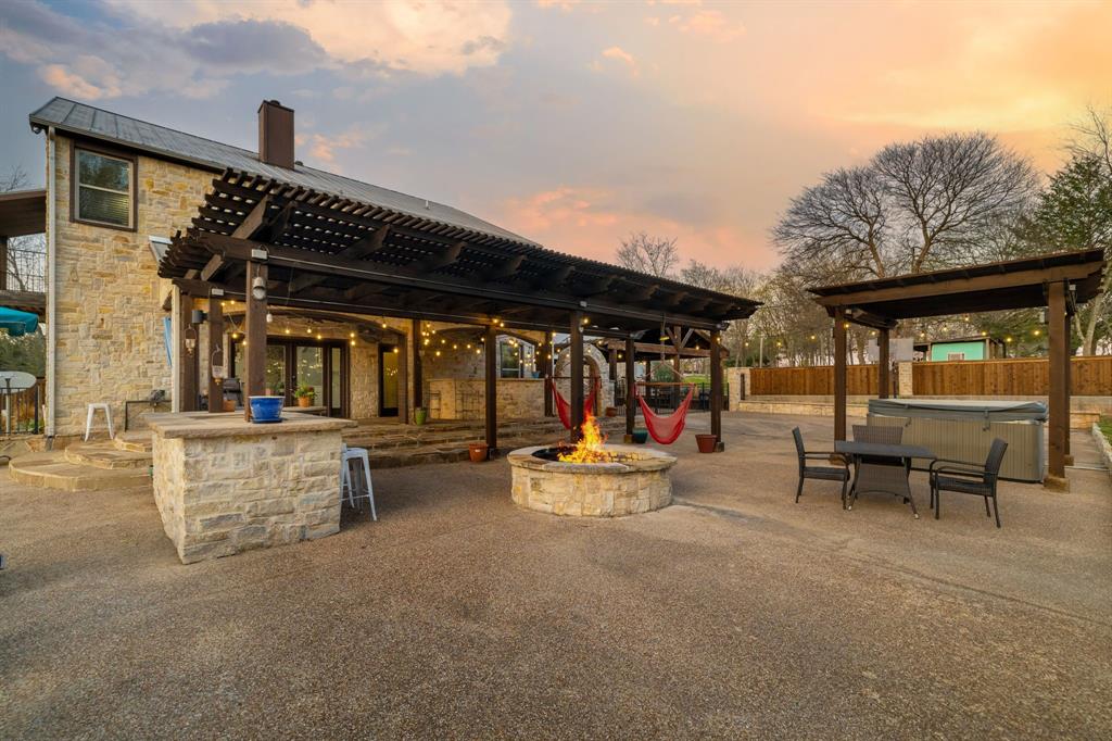 689 Jim Cannon Road Van Alstyne, TX 75495 - Photo 29 of 35 Patio terrace at dusk featuring a patio, a pergola, a hot tub, and a fire pit