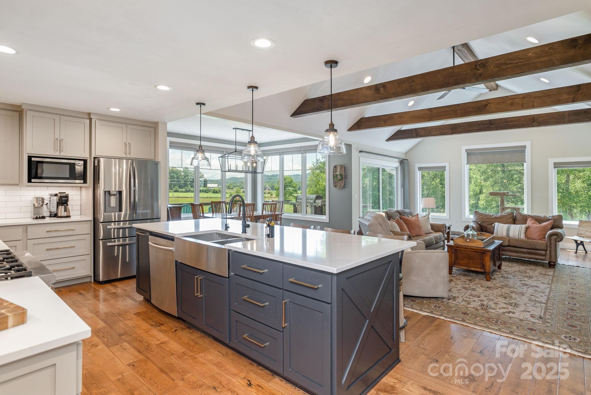 16 School House Road Mills River, NC 28759 - Photo 13 of 48 a large kitchen with kitchen island granite countertop a large counter top stainless steel appliances a stove a refrigerator a sink a dining table and chairs