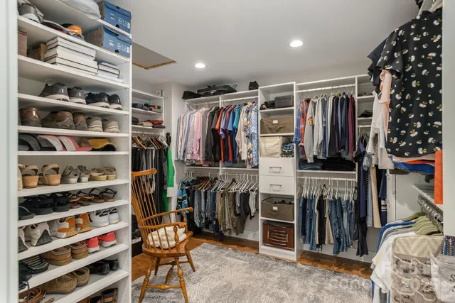 a view of walk in closet with clothes and shoes