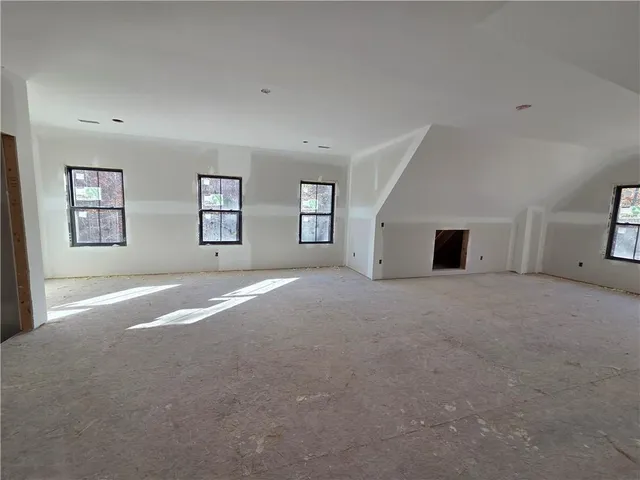 a view of empty room with a fireplace and window