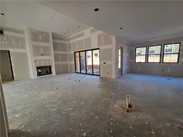 an empty room with windows and fireplace