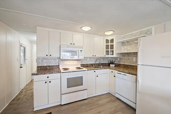 a kitchen with stainless steel appliances granite countertop a sink and a refrigerator