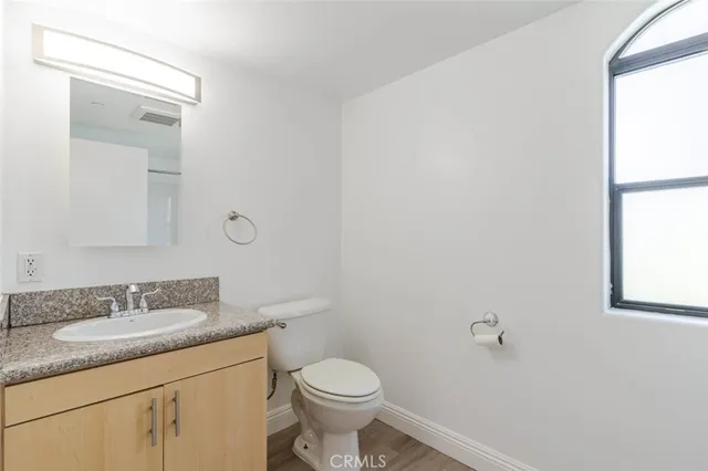 a bathroom with a granite countertop toilet sink and mirror