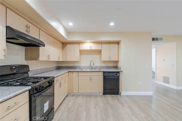 a kitchen with stainless steel appliances granite countertop a stove and a sink