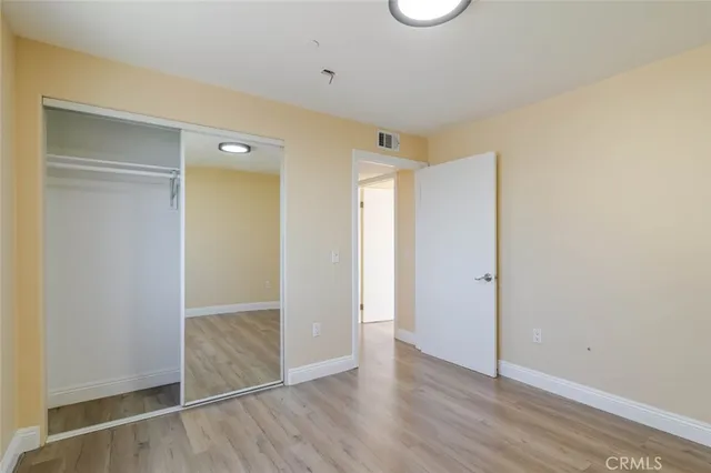 an empty room with wooden floor & windows