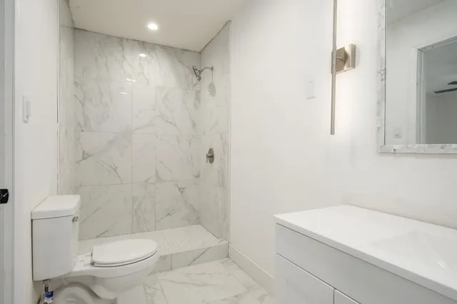 a white toilet sitting next to a bath tub