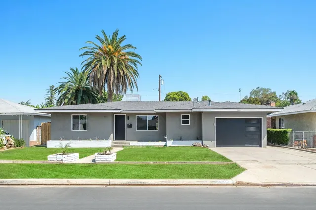 a front view of a house with a garden and yard
