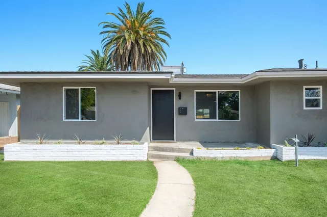 a view of house with yard and swimming pool