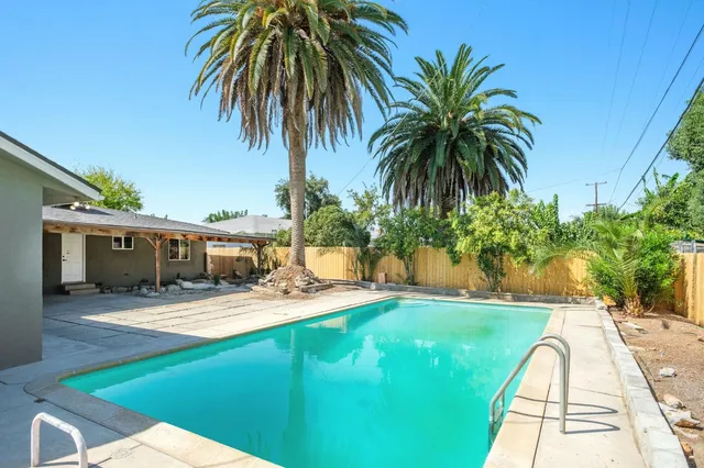 a view of a house with swimming pool and sitting area