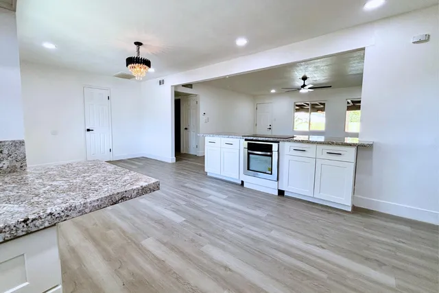 a view of a kitchen with a sink a refrigerator and a stove top oven