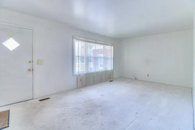 a view of kitchen with cabinets and window