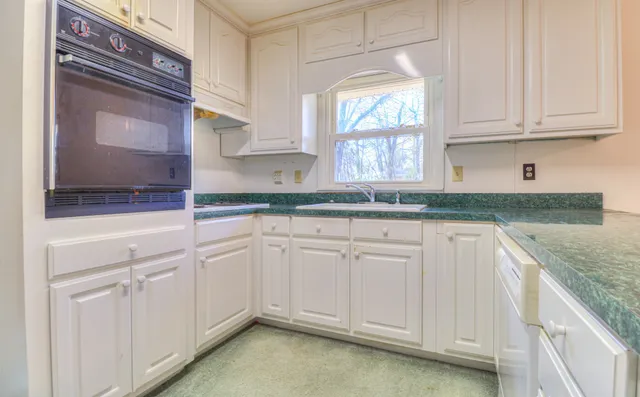 a kitchen with granite countertop white cabinets white appliances and a granite counter tops