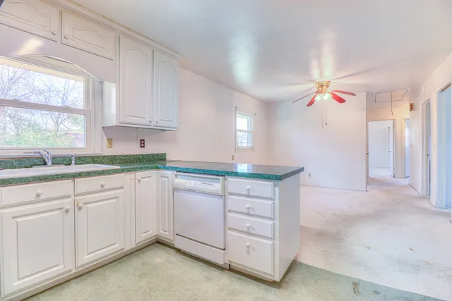 an empty room with closet and a chandelier fan