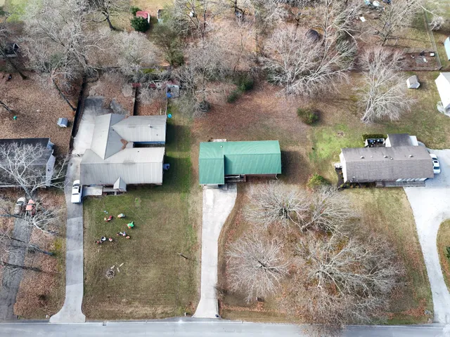 a view of a house with a yard and large tree