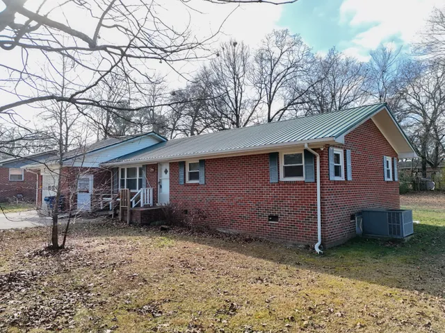 a front view of a house with two chairs and wooden fence