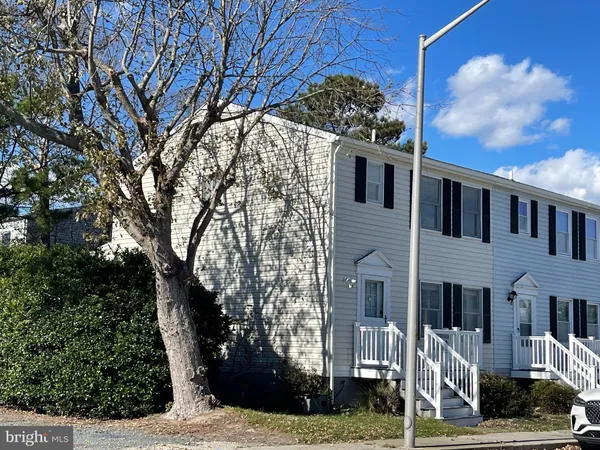 a front view of a house with a tree