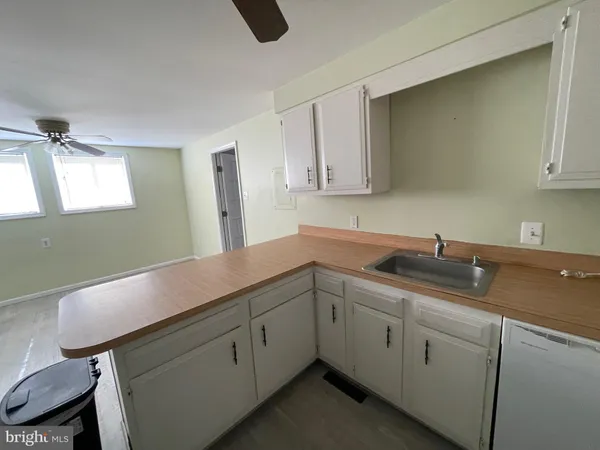 a kitchen with a sink cabinets and wooden floor
