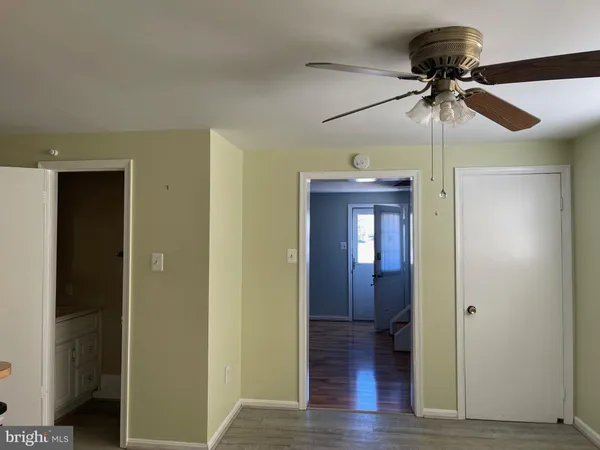 a view of a hallway with wooden floor and chandelier