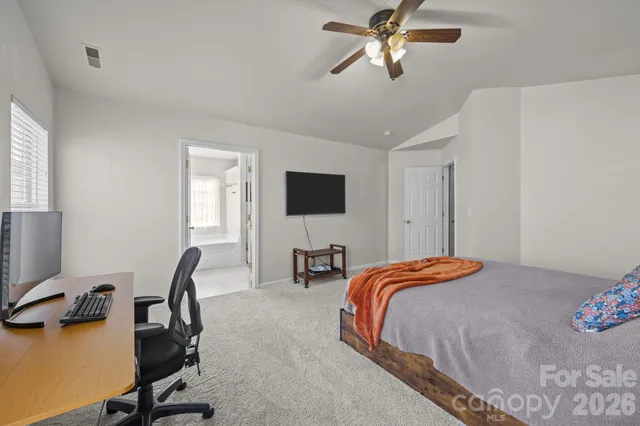 a bedroom with bed tv and a window