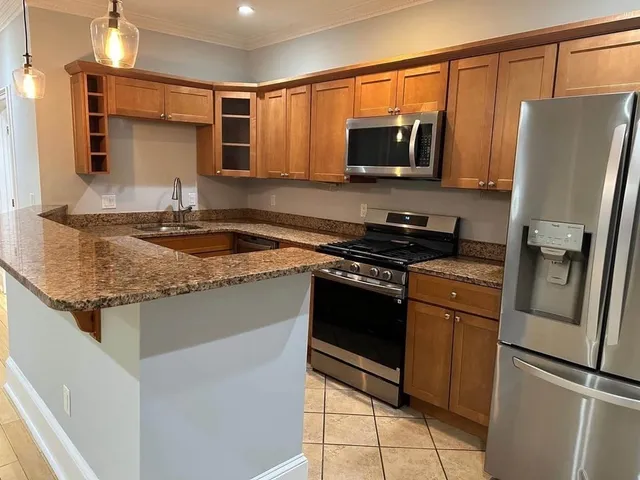 a kitchen with granite countertop a refrigerator and a sink