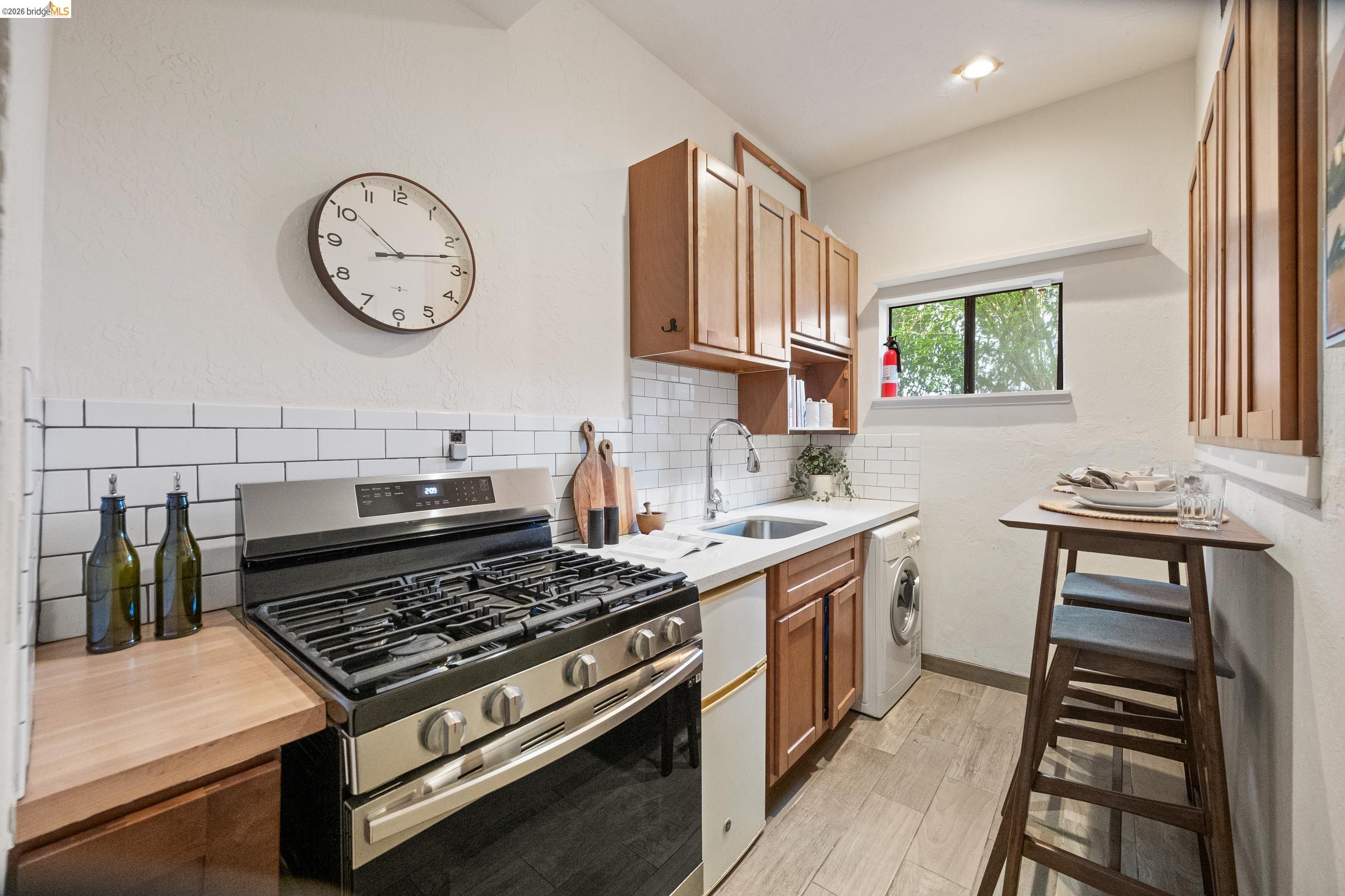 6600 Heather Ridge Way Oakland, CA 94611 - Photo 53 of 66 Compact kitchen featuring a stainless steel range, light wood-finish countertops, white subway tile backsplash, and wood-finish cabinetry