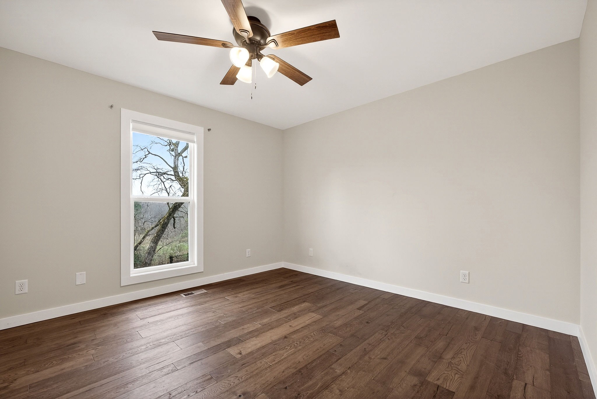4140 Eller Ridge Road Cookeville, TN 38506 - Photo 23 of 33 an empty room with wooden floor chandelier fan and windows