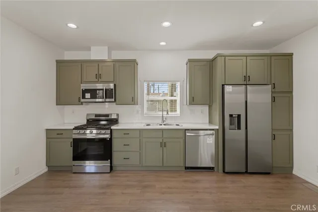 a kitchen with stainless steel appliances a stove a sink and a refrigerator