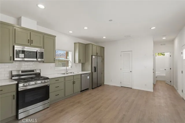 a kitchen with stainless steel appliances granite countertop a stove a sink and a refrigerator