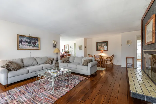 a living room with furniture a fireplace and wooden floor