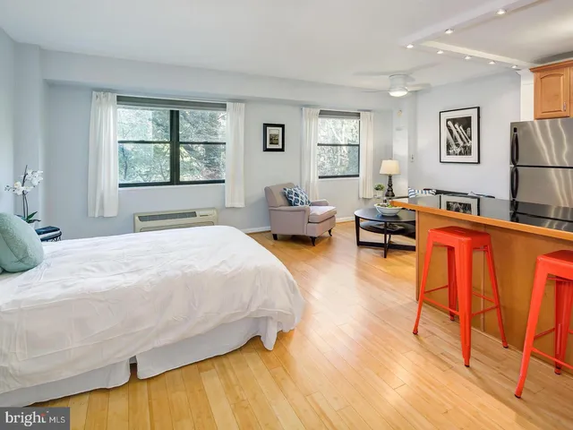 a spacious bedroom with a bed a couch and a window