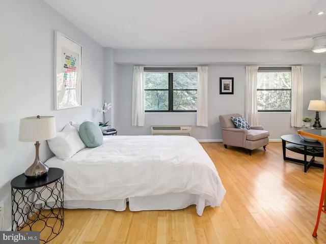a spacious bedroom with a bed and wooden floor