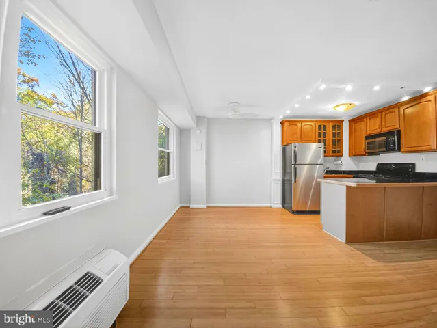 a view of kitchen with stainless steel appliances granite countertop a refrigerator and a stove top oven