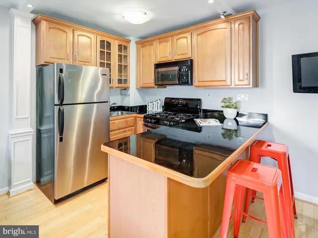 a kitchen with stainless steel appliances granite countertop a refrigerator a stove top oven a sink and dishwasher
