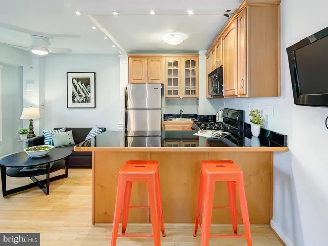 a living room with furniture a flat screen tv and kitchen view