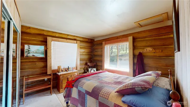 a bedroom with a bed and a large window with balcony view
