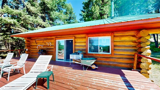 a view of a patio with table and chairs with wooden floor and fence