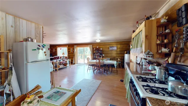 a living room with furniture a dining table and a refrigerator