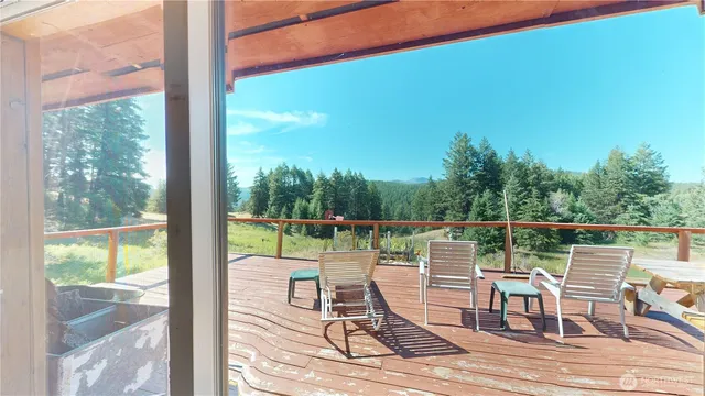 a balcony with wooden floor table and chairs
