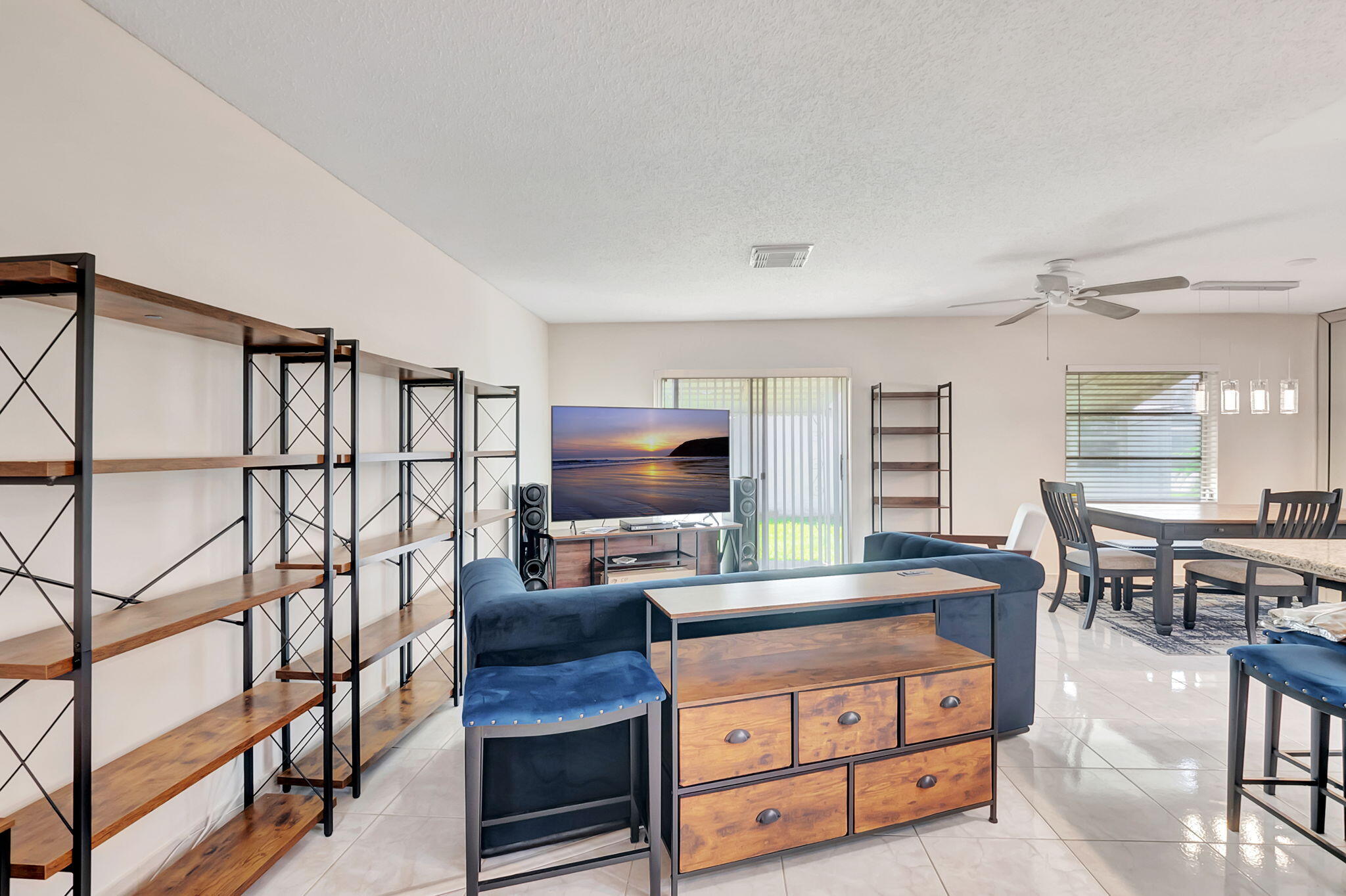 6078 Dusenburg Road Delray Beach, FL 33484 - Photo 11 of 78 a living room with furniture a flat screen tv and kitchen view