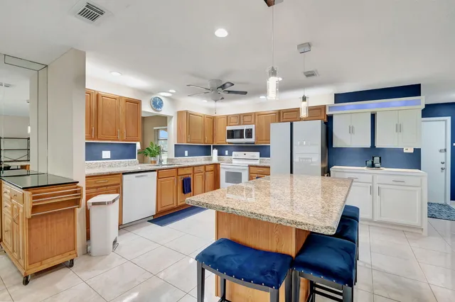 a living room with furniture a flat screen tv and kitchen view