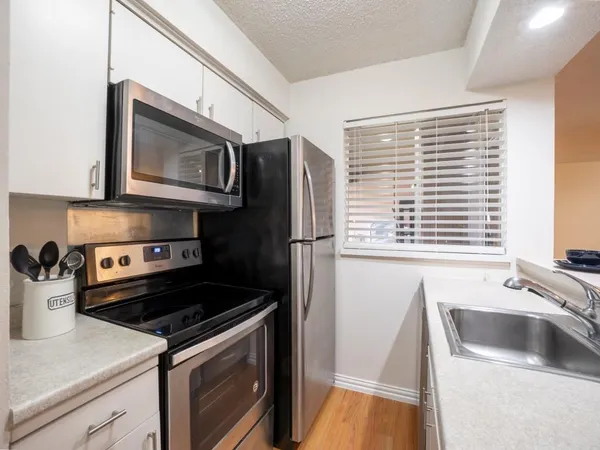 a kitchen with a sink a refrigerator and window
