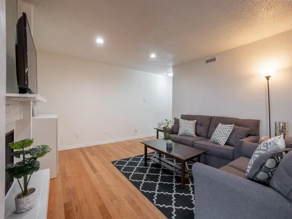 a living room with furniture a wooden floor and next to a window